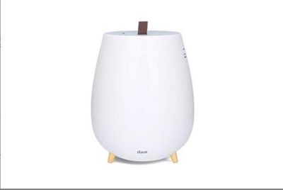 un humidificateur blanc posé sur un socle en bois