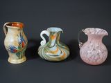 three different colored vases sitting next to each other on a black surface