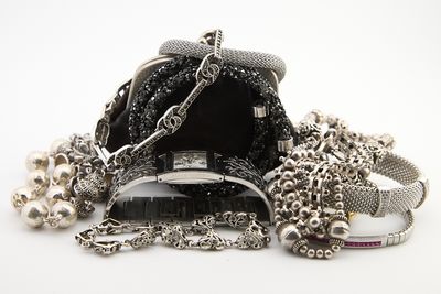 un sac à main noir entouré d'une chaîne, posé sur une surface blanche