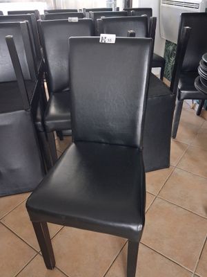 a lot of black leather chairs in a store