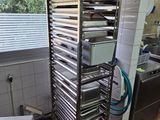 une étagère métallique avec des plateaux posés dessus, dans une cuisine
