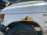 une camionnette blanche rouillée garée sur le bord de la route