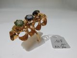 une image représentant une bague en or sertie de pierres noires et vertes