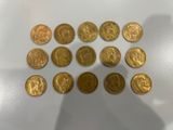 a bunch of gold coins sitting on top of a white surface