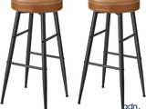 une paire de tabourets en cuir marron avec des pieds en métal
