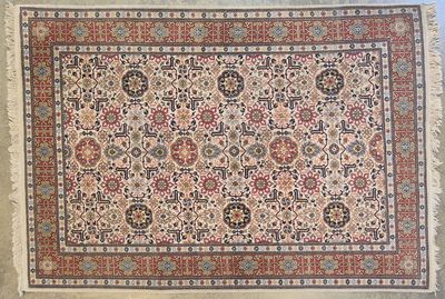 un tapis persan ancien avec un motif floral et des franges