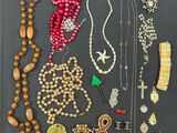 many different necklaces and bracelets laid out on a table