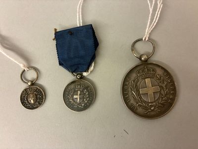 trois médailles et une médaille posée sur une table blanche