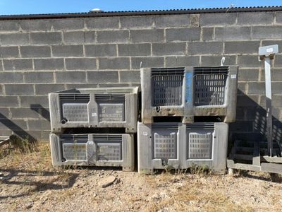 many crates stacked on top of each other in front of a brick wall