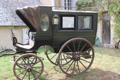 a horse drawn carriage that is parked in the grass