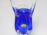 un vase en verre bleu contenant une fleur bleue