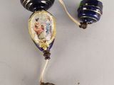pair of blue and gold glass bead earrings with a picture of a woman