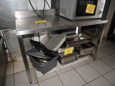 une étagère métallique avec des casseroles et des poêles dans une cuisine