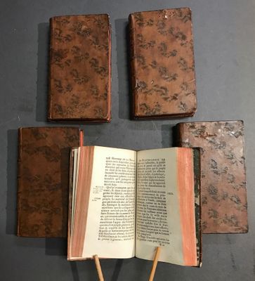 Plusieurs livres sont posés sur une table, avec des baguettes en bois à côté.