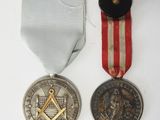two medals and a medal on a white surface