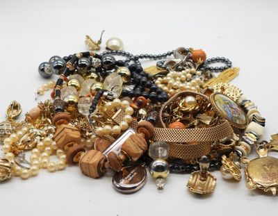 a pile of assorted jewelry on a white surface