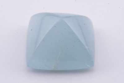 une image représentant une pierre bleu clair posée sur une surface blanche