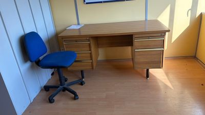 un bureau avec une chaise bleue et un tableau accroché au mur