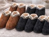 quatre paires de chaussons en peau de mouton pour femme posées sur un lit