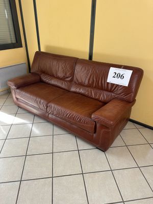 un canapé en cuir marron sur lequel est accrochée une étiquette de prix