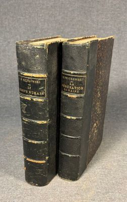 two old books sitting on top of each other on a table