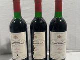 three bottles of wine sitting on top of a white table