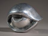a silver sculpture of a shell on a table