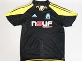 Le t-shirt est noir et jaune et porte un logo.