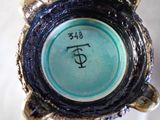 a close up of a blue vase with a black base