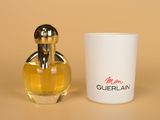 a small bottle of perfume next to a small cup