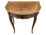 une petite table en bois sur laquelle se trouve un plateau sculpté