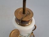 a small white vase with a gold lid and a brass handle on it