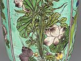 a green vase with flowers on it on a table