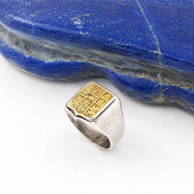 a close up of a ring on a rock with a stone in the background