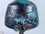 a blue vase with a bird on it on a stand