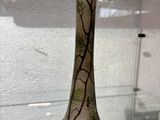 une vitrine en verre sur laquelle est posé un vase en verre