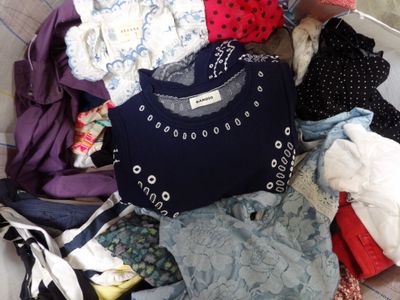 a pile of clothes that is on a bed