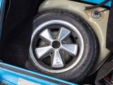 a tire in the trunk of a car with a flat tire