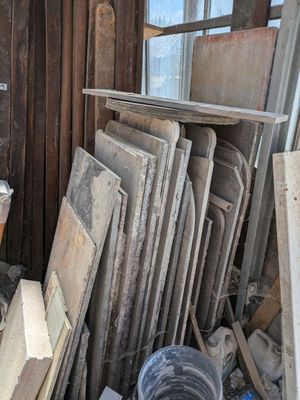 Plusieurs morceaux de bois sont empilés en tas près d'une fenêtre