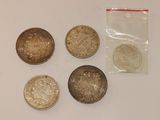 several coins are sitting on a table next to a plastic bag