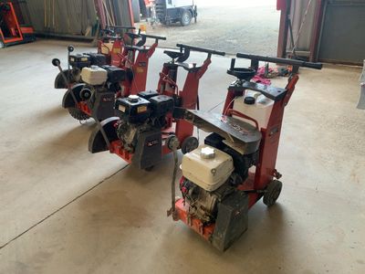 Plusieurs petites machines sont alignées en rang dans un garage.
