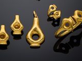several pieces of gold are arranged on a black surface