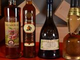 three bottles of wine sitting on a red table cloth