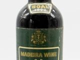 an old bottle of wine sitting on top of a white surface