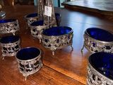 six blue glass bowls sitting on a wooden table