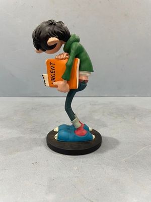 figurine of a boy with a book on a table