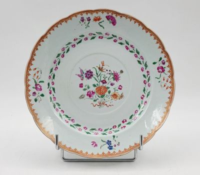 une photo d'une assiette décorée de fleurs, posée sur un support