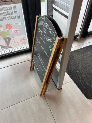 une affiche placée sur le trottoir devant un restaurant
