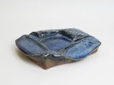 a small blue bowl on a table with a white background