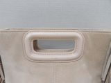 beige sued purse with handle and fringes on a white background